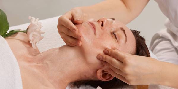 cosmetologist doing facial massage to a girl in a beauty salon, beauty procedures for smoothing the skin